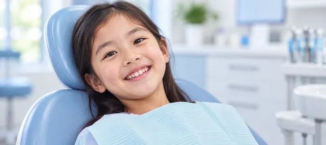 A smiling child sitting comfortably in a dental chair